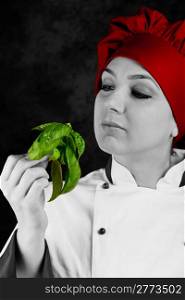 photo of young female chef controlling basil quality