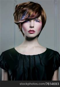 Photo of young lady with bright makeup and modern hairstyle. Beautiul woman in photography studio.
