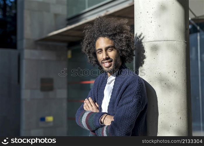 Photo portrait of cheerful man with crossed hands smiling confident walking on street in summer