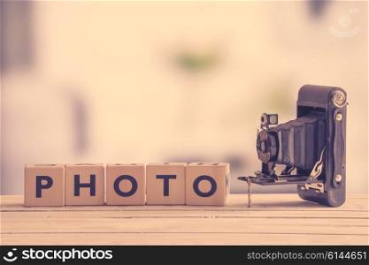 Photo sign with a vintage camera on a wooden table