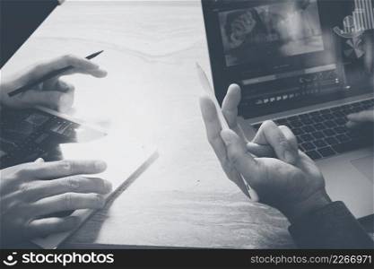 Photo website graphic designer hand meeting team with new project modern studio.Modern laptop digital tablet smart phone on marble table.Books papers documents, sun flare effect, black white 