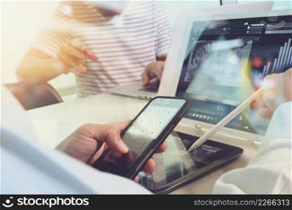 Photo website graphic designer hand working with new project modern studio.Modern laptop digital tablet smart phone on wood table.Books papers documents. Blurred background, sun flare effect 
