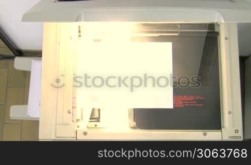 Photocopier scanning document. High angle view. 30p
