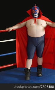Photograph of a Mexican wrestler or Luchador standing in a wrestling ring.