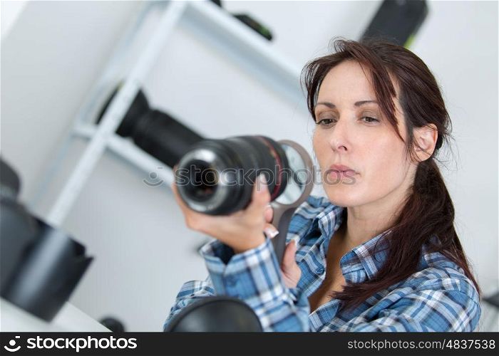 photographer checking a lens with a magnifying glass