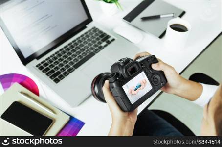 photographer checking dslr camera on desk