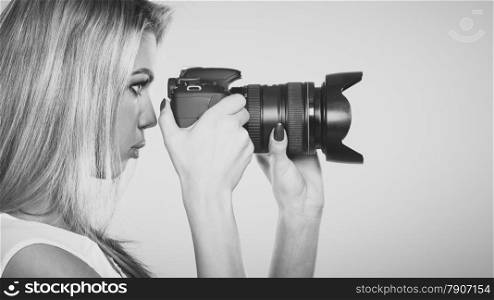 Photographer girl shooting images. Attractive blonde woman face profile taking photo with camera. Black white photo