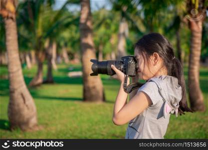 photographer little girl takes a photo on the garden