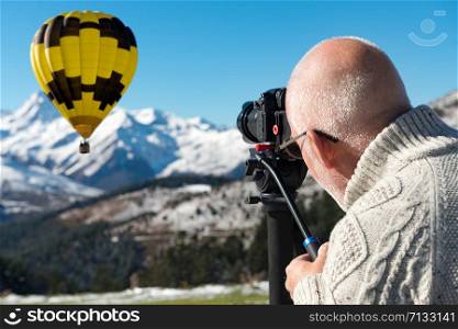 photographer on top of the mountain with hot air balloon