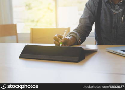 photographer retouching photo, graphic designer drawing image using a digital tablet, pen and computer laptop