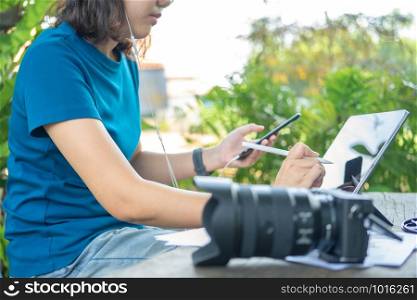 Photographer sitting and editing photos using a tablet. Portable size, smart features In a coffee shop or cafe