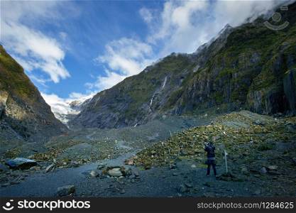 photographer taking a photograph in franz josef glacier one of most popular natural traveling destination in southland new zealand