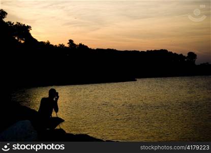 photographer taking photos on pink sunset at Black Sea Bulgaria