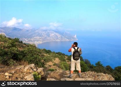 Photographer-traveler photographs the beautiful sea Crimean landscape from the top of the mountain, Karaul-Oba, Sudak, Crimea, Ukraine