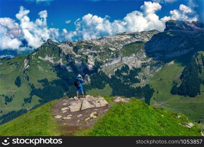 Photographer traveler takes a photo of the alpine valley on a Mannlichen mountain viewpoint, Bernese Oberland Switzerland. Mannlichen viewpoint, Switzerland