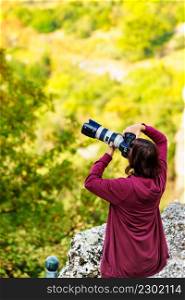 Photographer woman taking pictures of nature. Tourist female enjoying her hobby and passion using professional camera.. Photographer woman taking pictures of nature