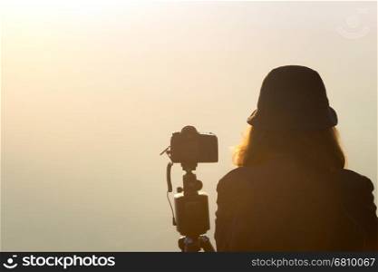 photographer woman waiting to take landscape photo in fog view during morning time