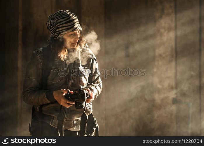 photographer women travel with black digital camera. she breathe smoke out because cold weather. she stand wooden background.