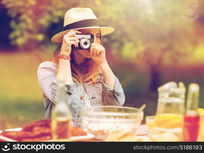 photography and people concept - close up of young woman with camera photographing at dinner in summer garden. close up of woman with camera shooting outdoors