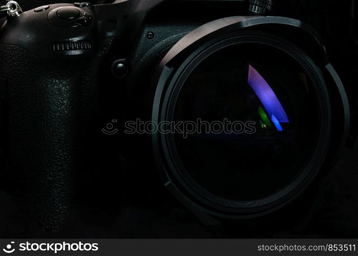 Photography occupation background image concept - professional modern DSLR camera with wide lens in close-up ( low key light)