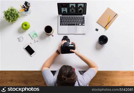 photography, people and technology concept - woman with camera and laptop computer at office table. woman with camera and laptop at office table