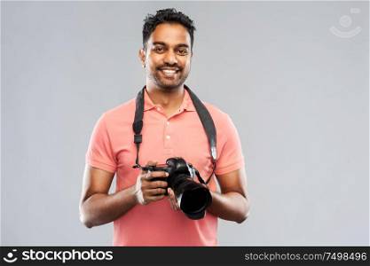 photography, profession and people and concept - happy indian man or photographer with digital camera over grey background. indian man or photographer with digital camera