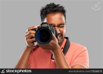photography, profession and people and concept - happy indian man or photographer with digital camera over grey background. indian man or photographer with digital camera