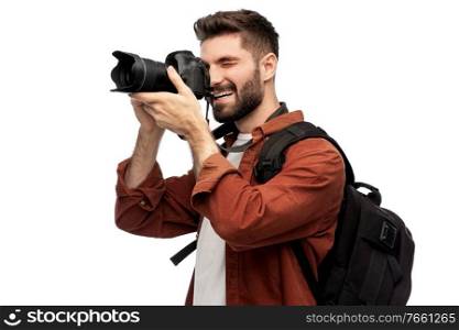 photography, travel and people and concept - happy smiling man or photographer with digital camera and backpack taking picture over white background. happy man or photographer with camera and backpack