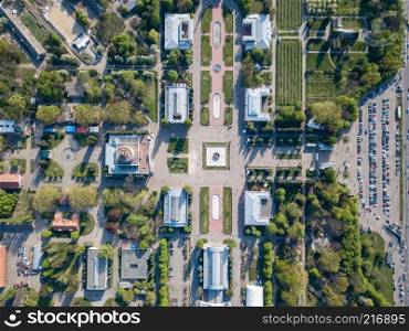 Photos from the drone with a view of the buildings and symmetrical square of the National Exhibition Center with parking for cars in Kiev, Ukraine.. Top view of the building and square of the National Exhibition Center with parking for cars in Kiev, Ukraine.