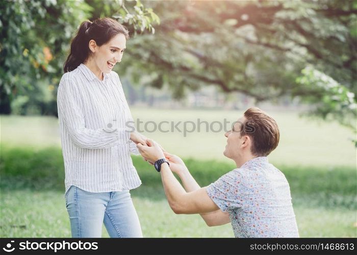Photos of engagements, marriage proposals, and newly engaged couples lover young man and lady outdoor green park.
