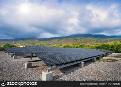 Photovoltaic modules solar power plant in Green tree at landscape lake views nature forest Mountain views spring with white cloud background, Alternative energy concept and Clean energy.