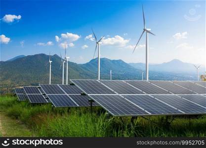 Photovoltaic modules solar power plant with wind turbines against mountains landscape against blue sky with clouds,Alternative energy concept,Clean energy,Green energy.