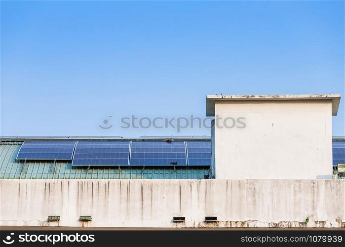 Photovoltaic solar panels on building roof on blue sky background, energy system electricity generation,Alternative energy concept.