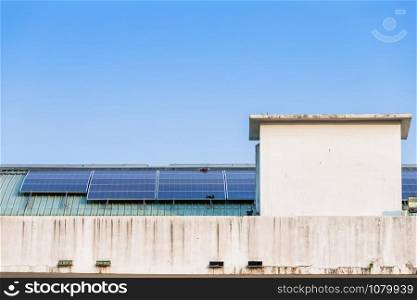 Photovoltaic solar panels on building roof on blue sky background, energy system electricity generation,Alternative energy concept.