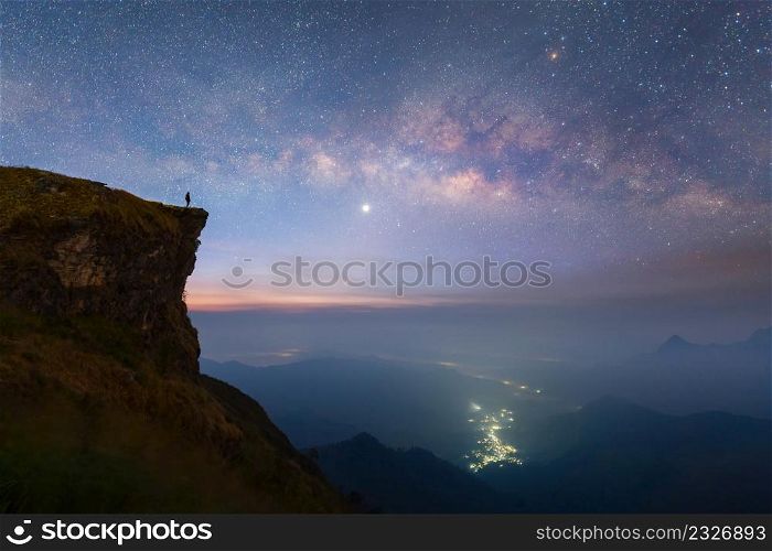 Phu Chi Fa, Chiang Rai, Thailand with mountain hills, the milky way with bright stars on blue sky at night. Natural universe space landscape background. It is the galaxy that contains our Solar System
