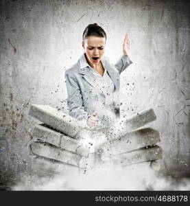 Physical strength. Image of businesswoman breaking bricks with hand