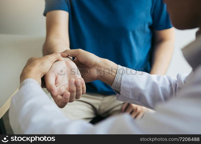 Physical therapist checks the patient wrist by pressing the wrist bone in clinic room.