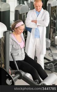 Physical therapist male assist active senior woman exercise at gym