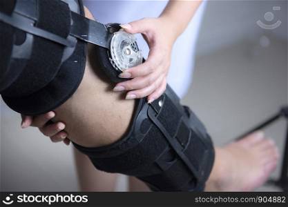 Physical therapists adjust the knee brace to the patient's