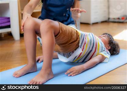 Physical therapy for kids, child doing a bridge with a physical therapist, core strengthening exercise