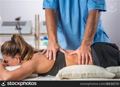Physical therapy. Therapist addressing lower back muscles