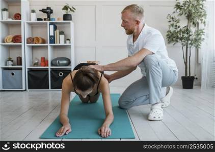 physician during physiotherapy session with female patient