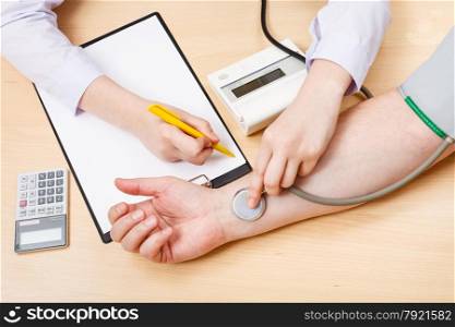 physician makes appointment and measures blood pulse of patient