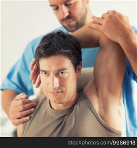 Physiotherapist doing healing treatment on man’s arm, Therapist wearing blue uniform, Osteopath,  Chiropractic adjustment, 