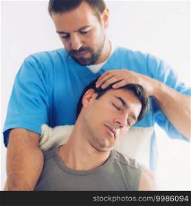 Physiotherapist doing healing treatment on man"s neck, Therapist wearing blue uniform, Osteopath,  Chiropractic adjustment, 