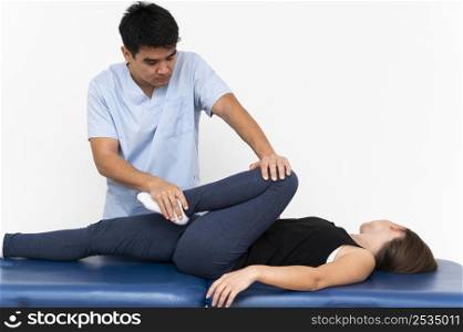 physiotherapist doing leg exercises with female patient