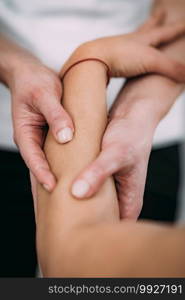 Physiotherapist massaging female patient with injured arm. Sports injury treatment.. Arm Sports Massage Therapy