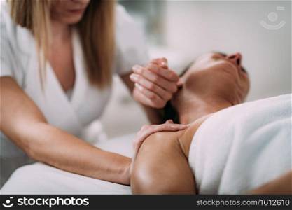 Physiotherapist massaging female patient with injured neck. Sports injury treatment.. Neck Sports Massage Therapy