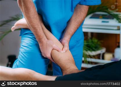 Physiotherapist massaging male patient with injured calf. Sports injury treatment.. Calf Sports Massage Therapy