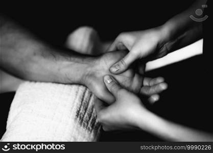 Physiotherapist massaging male patient with injured hand muscle. Sports injury treatment.